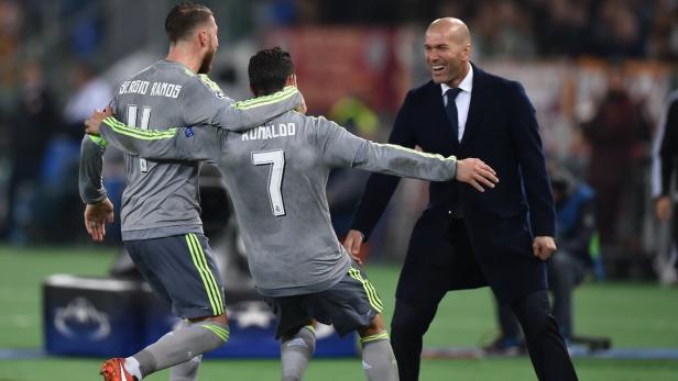 Sergio Ramos und Cristiano Ronaldo werden von Trainer Zinedine Zidane umarmt.