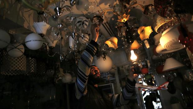 Ein Mann betrachtet in einem Geschäft eine Vielzahl von Lampen und Leuchten.