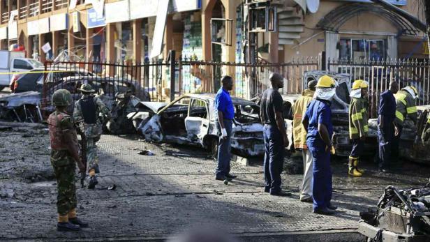 Nach einer Explosion stehen Soldaten und Rettungskräfte vor zerstörten Autos.