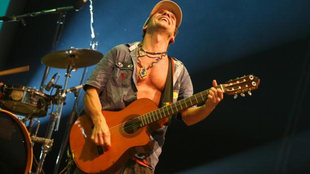 Ein Mann mit Gitarre tritt auf einer Bühne auf.