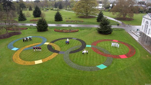 Eine Rasenfläche mit den Olympischen Ringen, die mit Blumen bepflanzt sind.