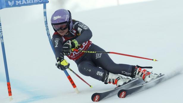 Eine Skirennläuferin fährt einen Slalomkurs hinunter.