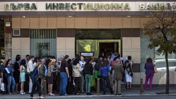 Eine Menschenmenge steht vor einer Filiale der „Първа инвестиционна банка“ Schlange.