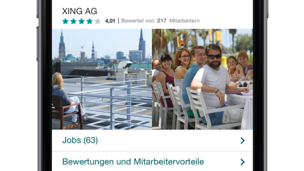 Eine Gruppe von XING-Mitarbeitern sitzt auf einer Dachterrasse in Hamburg zusammen.