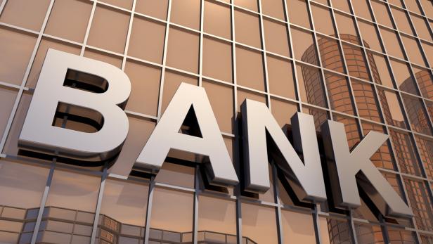 Die silberne Aufschrift „Bank“ an einer Glasfassade.