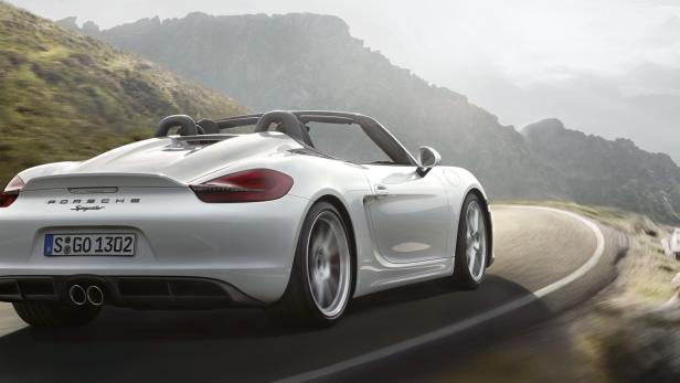 Ein weißer Porsche Spyder fährt auf einer kurvenreichen Bergstraße.