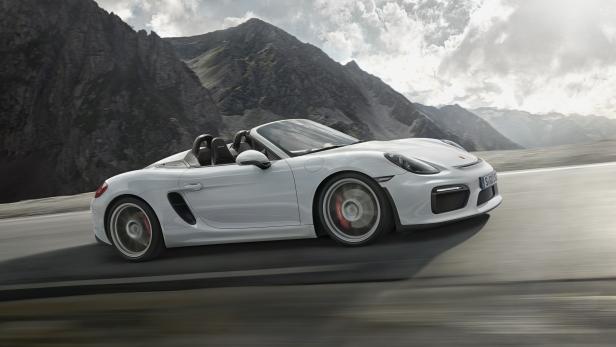 Ein weißer Porsche Boxster Spyder fährt auf einer Bergstraße.