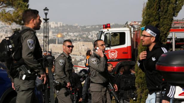 Polizisten stehen vor einem Feuerwehrauto in Jerusalem.