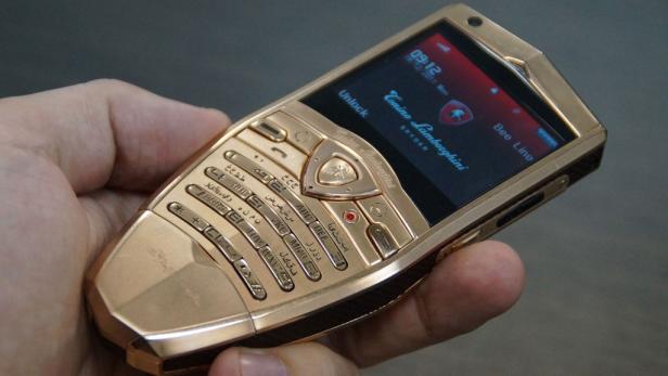 Ein goldenes Tonino Lamborghini Spyder Handy wird in der Hand gehalten.