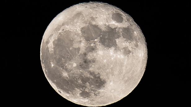 Nahaufnahme des Vollmonds vor einem schwarzen Nachthimmel.