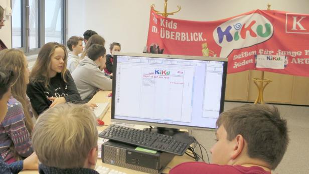 Eine Gruppe von Schülern arbeitet an Computern mit der KiKu-Webseite auf dem Bildschirm.