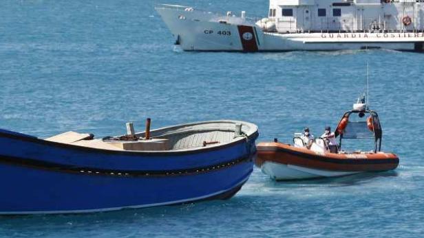 Ein blaues Fischerboot und ein Küstenwachboot auf dem Meer.