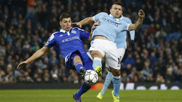 Zwei Fußballspieler kämpfen um den Ball auf dem Spielfeld.