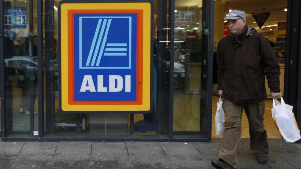 Ein Mann verlässt mit Einkaufstüten eine Aldi-Filiale.