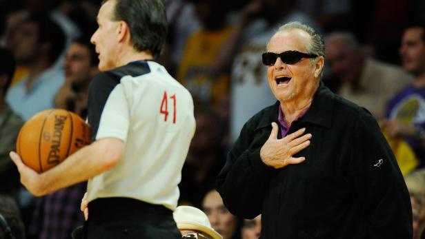 Jack Nicholson feuert bei einem Basketballspiel an, neben ihm ein Schiedsrichter.