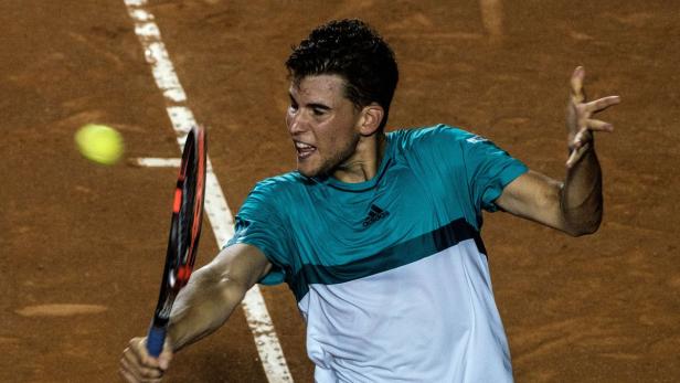 Dominic Thiem schlägt einen Tennisball auf einem Sandplatz.