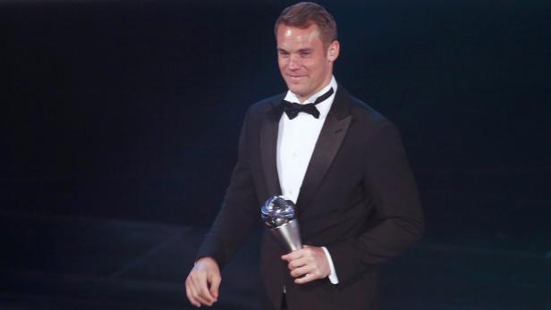 Manuel Neuer im Smoking mit einer Auszeichnung in der Hand.