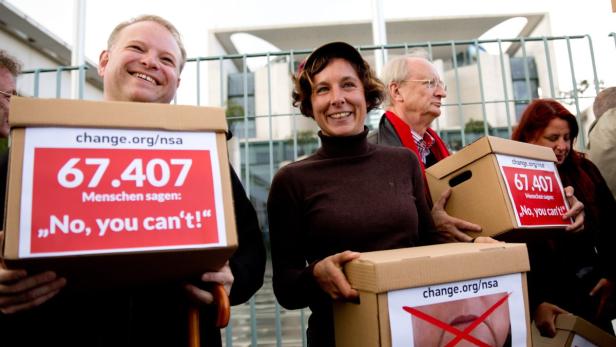 Menschen demonstrieren mit Kartons und Schildern gegen die NSA.