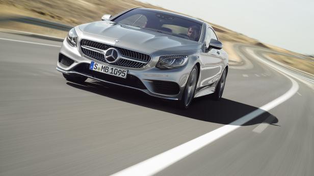Ein silbernes Mercedes-Benz S-Klasse Coupé fährt auf einer kurvenreichen Straße.