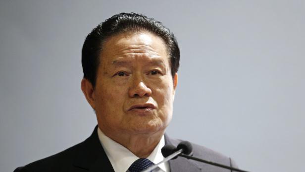 Ein Mann in Anzug spricht vor einem Mikrofon.