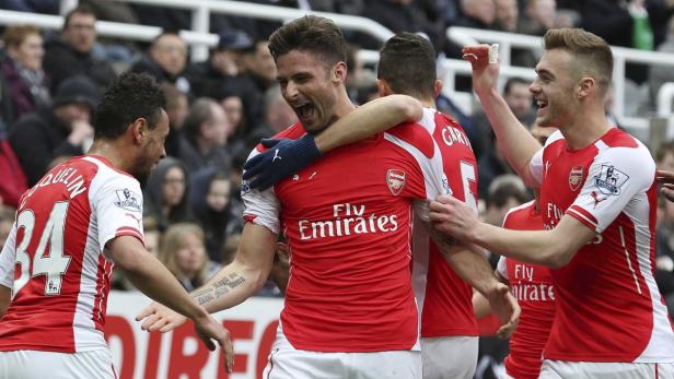 Olivier Giroud wird von seinen Teamkollegen nach einem Tor umarmt.