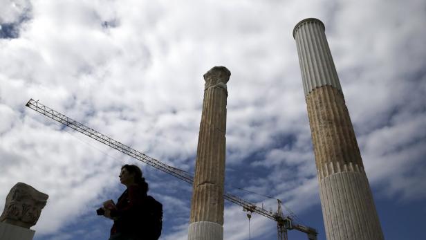 Eine Touristin fotografiert die Säulen des Olympischen Zeus Tempels in Athen.