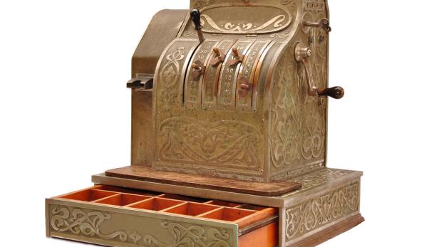 Eine antike Registrierkasse mit geöffneter Schublade und kunstvollen Verzierungen.