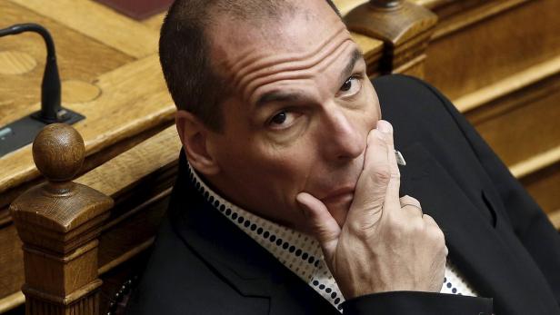 Ein Mann in einem Anzug sitzt nachdenklich da und stützt sein Kinn mit der Hand ab.