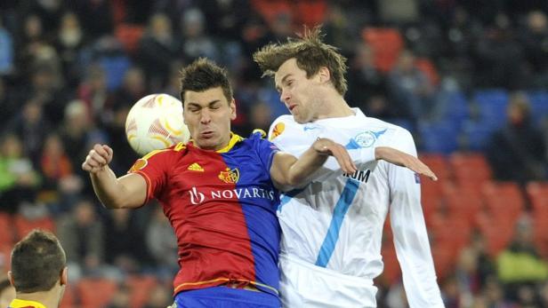 epa03614336 St. Petersburg&#039;s Nicolas Lombaerts (R) fights for the ball against Basel&#039;s Aleksandar Dragovic (2-R) during the UEFA Europa League round of 16 first leg soccer match between FC Basel and FK Zenit St. Petersburg at the St. Jakob-Park stadium in Basel, Switzerland, 07 March 2013. EPA/GEORGIOS KEFALAS