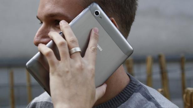 Ein Mann telefoniert mit einem Samsung Tablet am Ohr.