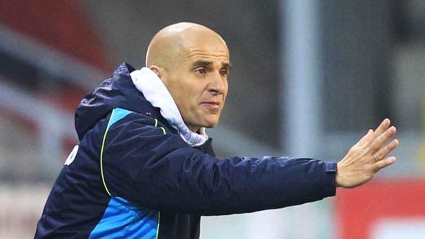 Ein Mann mit Glatze gestikuliert mit der Hand.