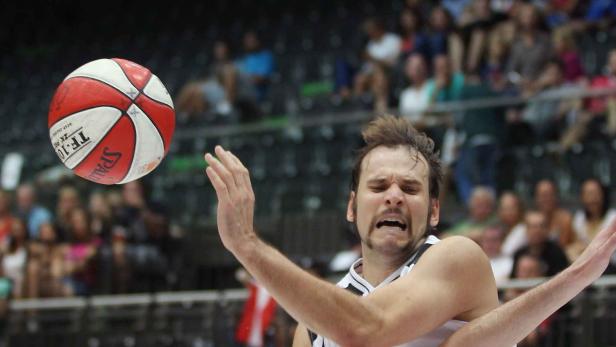 Ein Basketballspieler versucht, einen Ball abzuwehren.