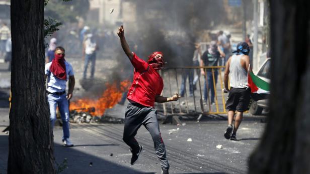 Palestinian throws a stone during clashes with Isr Krawalle bei Beerdigung von jungem Palästinenser