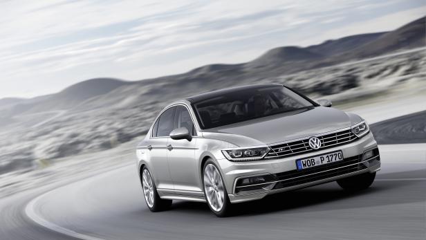 Ein silberner VW Passat fährt auf einer kurvenreichen Straße.