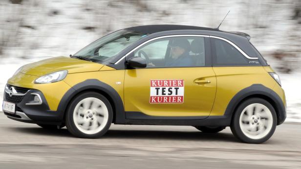 Ein gelber Opel Adam mit dem Aufdruck „Kurier Test“ fährt auf einer Straße.