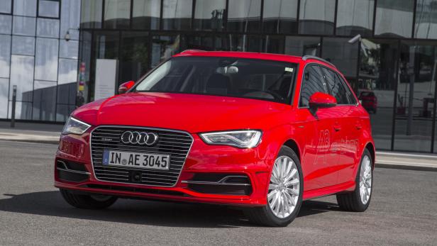 Ein roter Audi A3 e-tron steht vor einem modernen Gebäude.