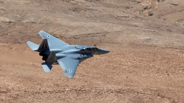Ein israelischer F-15 Eagle Kampfjet im Flug über einer Wüstenlandschaft.
