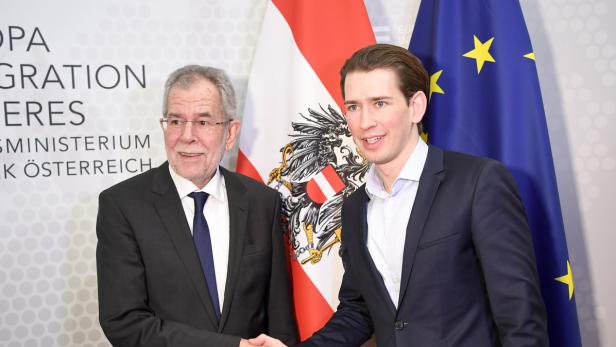 Alexander Van der Bellen und Sebastian Kurz schütteln sich vor österreichischen und EU-Flaggen die Hände.
