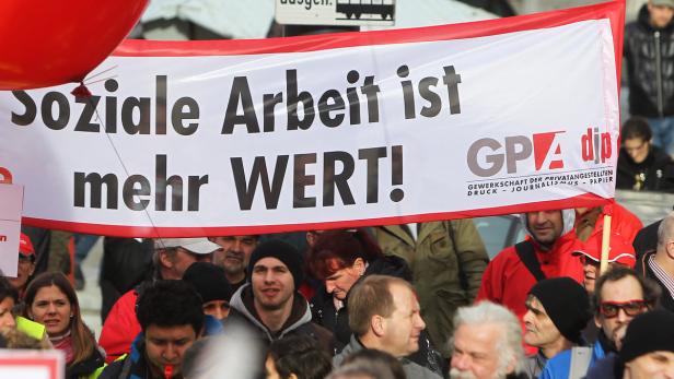 Demonstranten halten ein Banner mit der Aufschrift „Soziale Arbeit ist mehr WERT!“.
