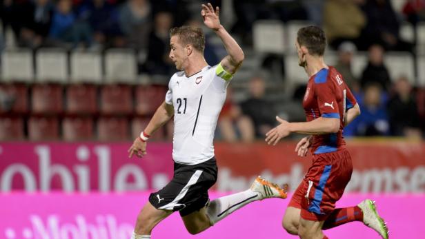 Ein österreichischer Fußballspieler im weißen Trikot mit der Nummer 21 im Spiel.