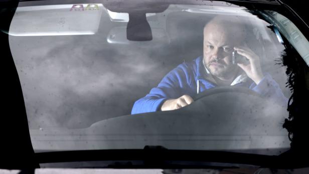 Ein Mann telefoniert während der Fahrt im Auto.