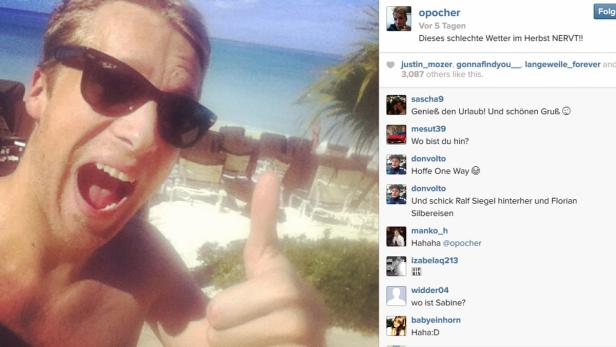 Oliver Pocher macht ein Selfie am Strand und zeigt den Daumen nach oben.
