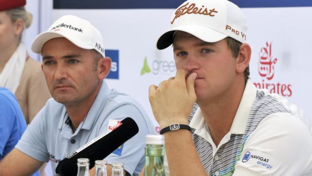 Zwei Golfspieler bei einer Pressekonferenz, beide tragen Kappen.