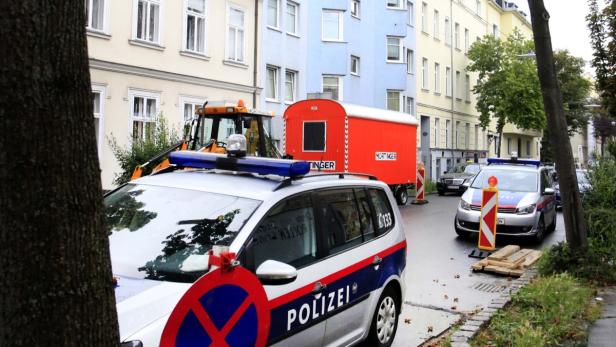 Ein Polizeiauto steht auf einer Straße mit Bauarbeiten in einer Stadt.