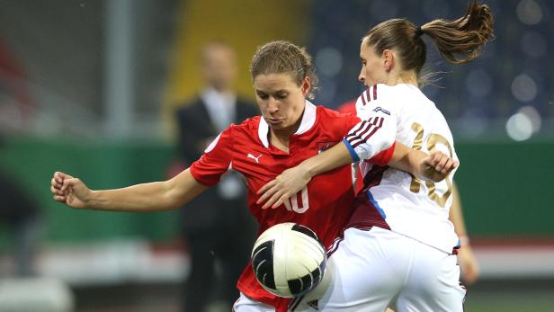 Zwei Fußballspielerinnen kämpfen um den Ball.
