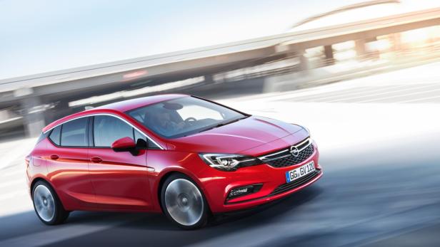 Ein roter Opel Astra fährt auf einer Straße entlang.