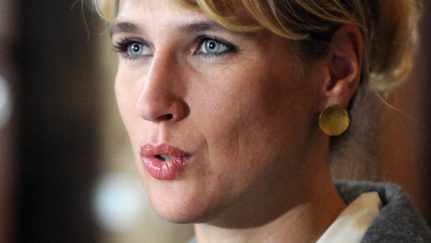 Nahaufnahme einer Frau mit blonden Haaren und einem goldenen Ohrring.