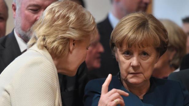 Angela Merkel gestikuliert während eines Gesprächs mit einer anderen Frau.