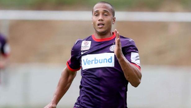 Ein Fußballspieler in lila Trikot läuft auf dem Feld.