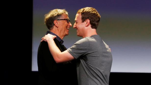 Bill Gates und Mark Zuckerberg umarmen sich lächelnd.